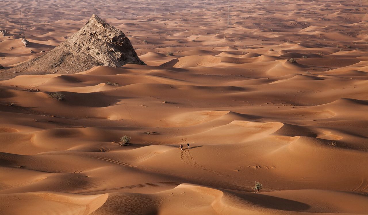 Aerial view of two people travelling through desert in sharjah