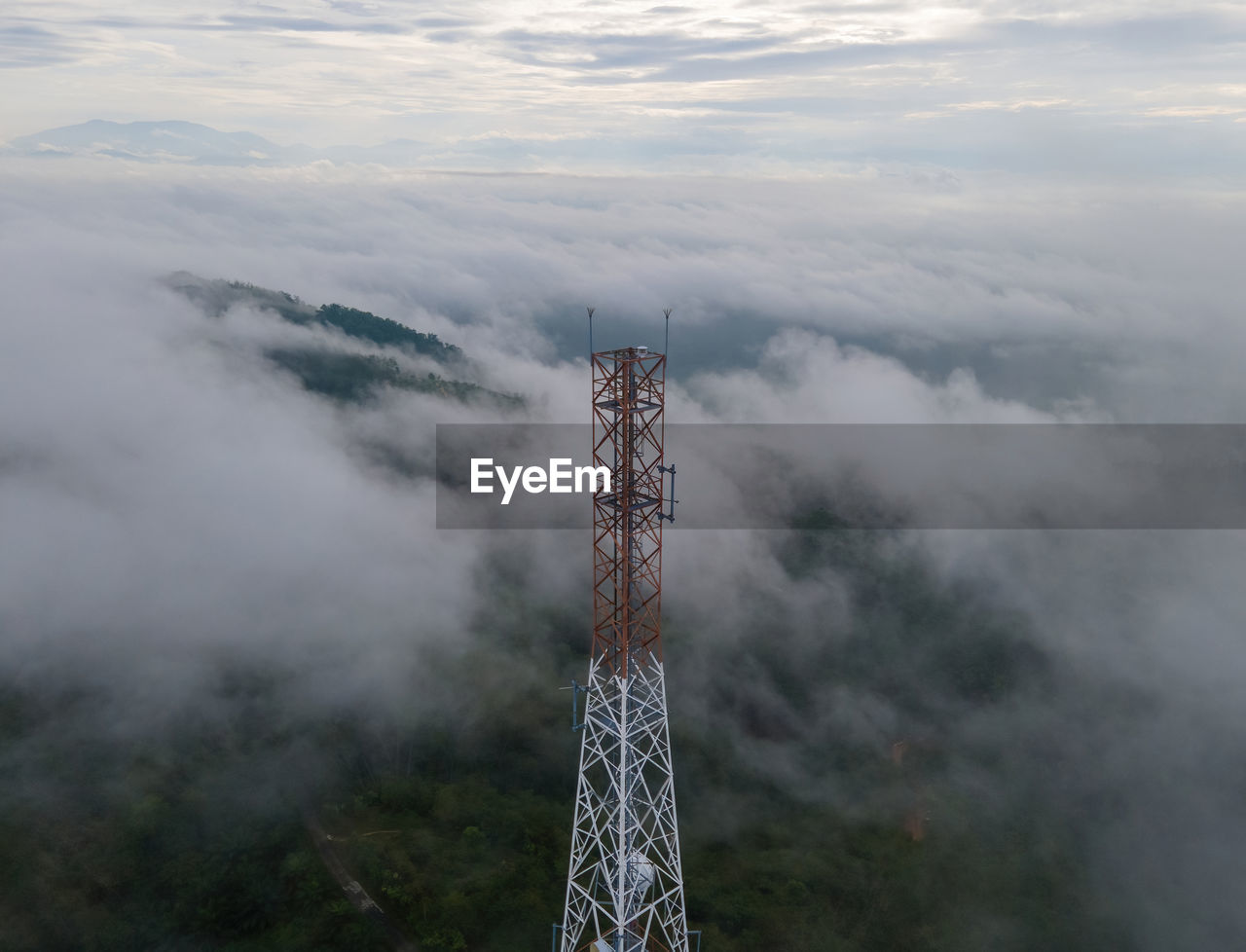 fog, cloud, mountain, sky, environment, nature, scenics - nature, beauty in nature, landscape, no people, outdoors, land, tower, architecture, forest, plant, tree, communication, non-urban scene, built structure, travel, day, travel destinations, mist, technology, tranquility, mountain range, summit, tranquil scene