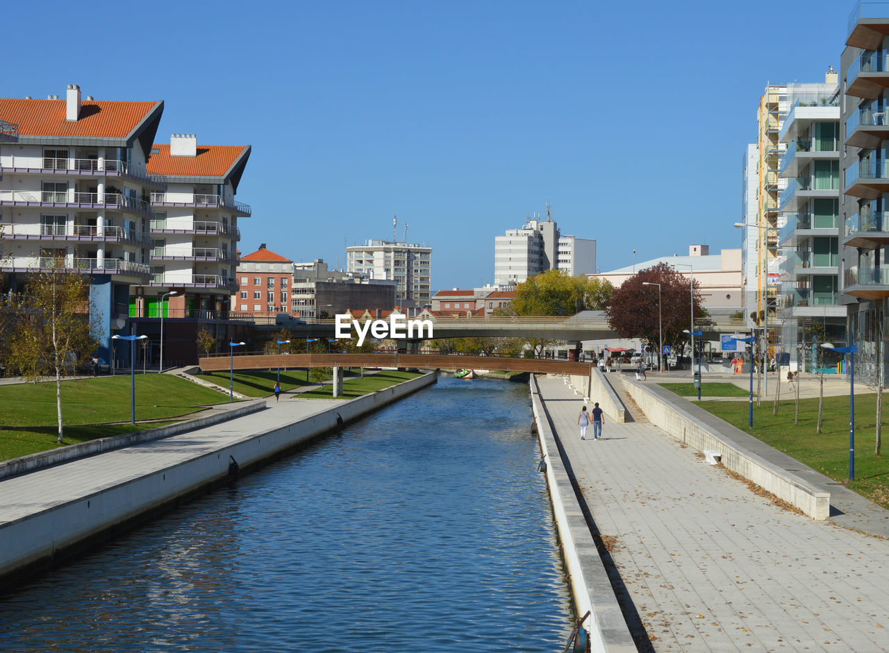 VIEW OF RIVER IN CITY AGAINST CLEAR BLUE SKY