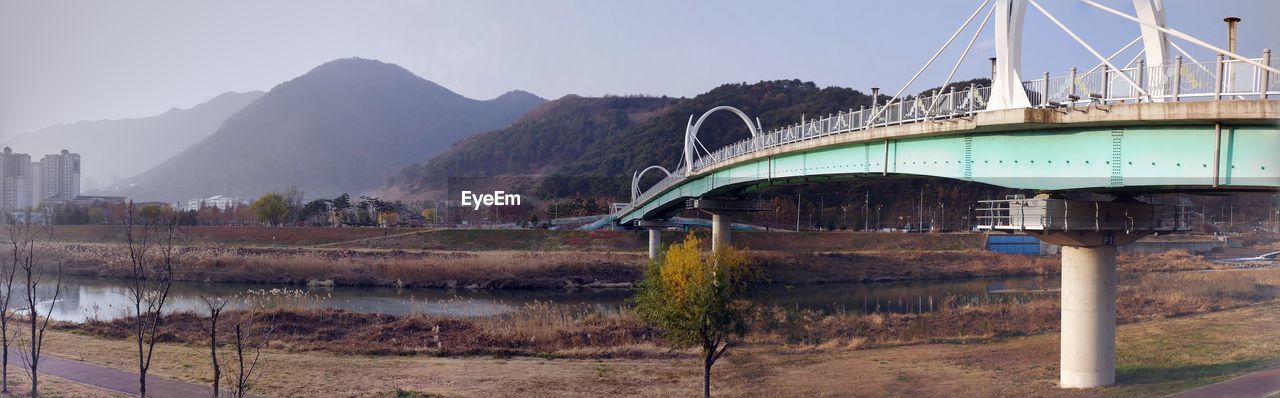 Bridge over river with mountain range in background