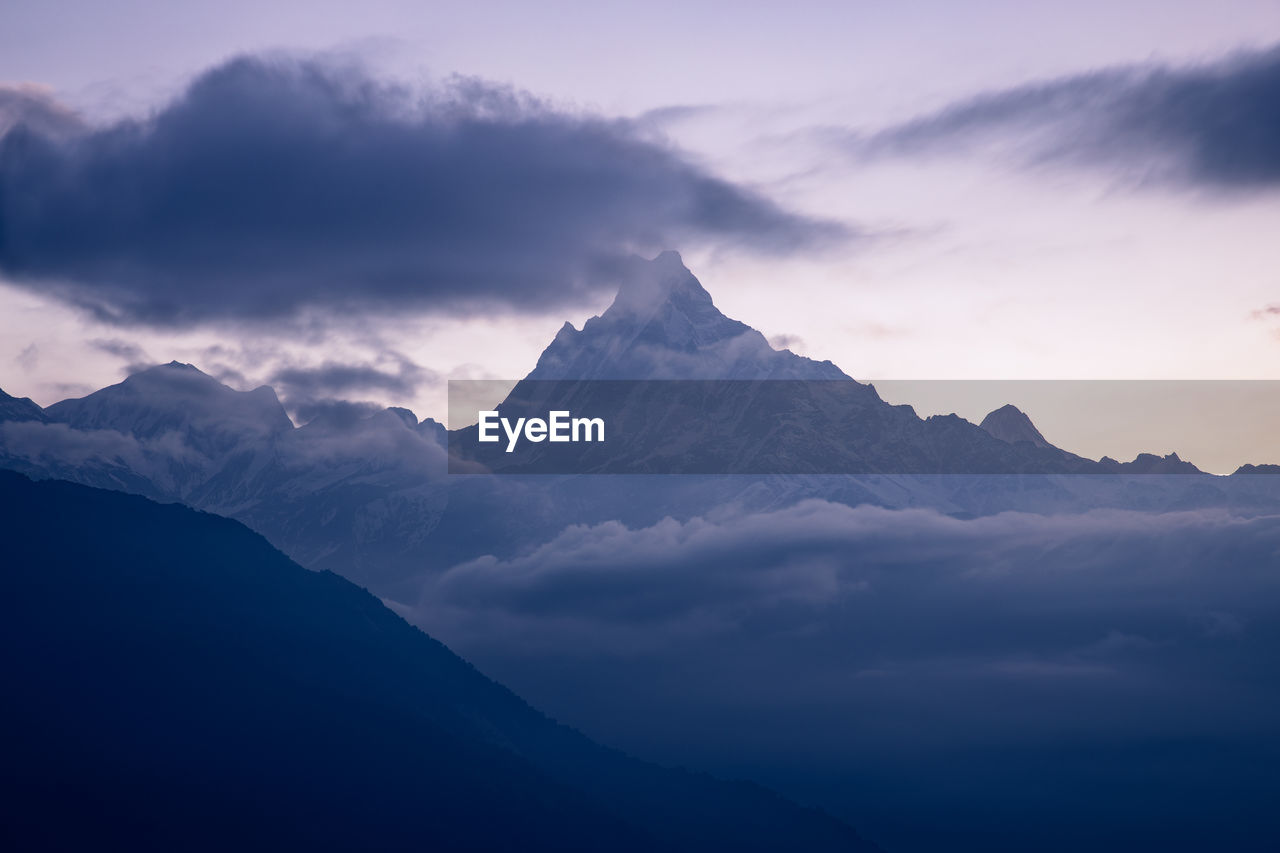 Scenic view of snowcapped mountains against sky during sunset
