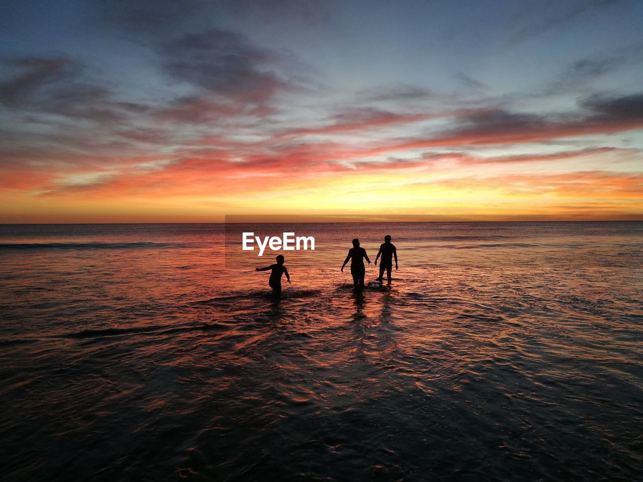 SILHOUETTE PEOPLE ON BEACH AT SUNSET