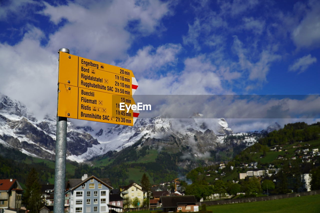 WARNING SIGN BY BUILDINGS AGAINST SKY