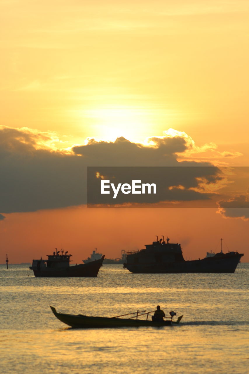 Silhouette boats on sea against sky during sunset