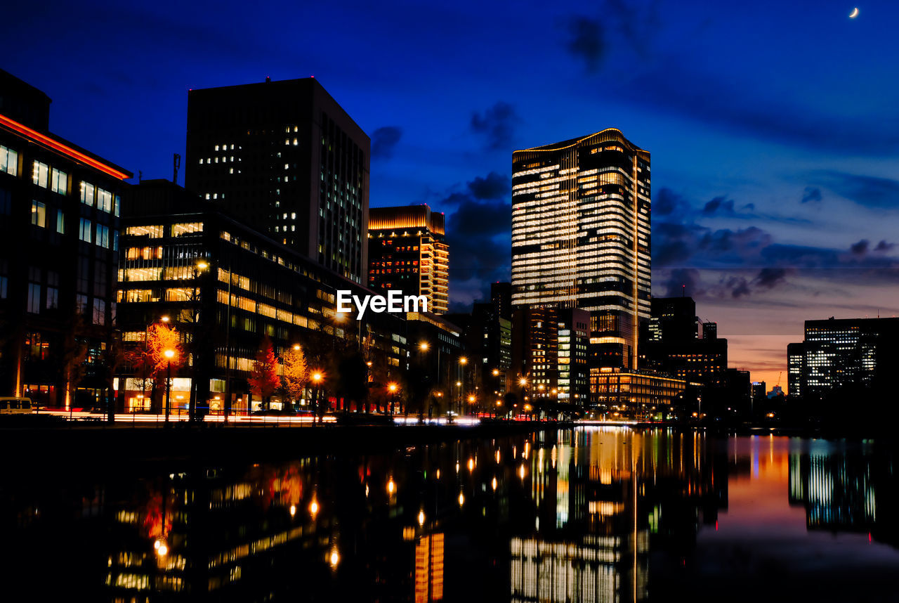 ILLUMINATED BUILDINGS BY CITY AT NIGHT