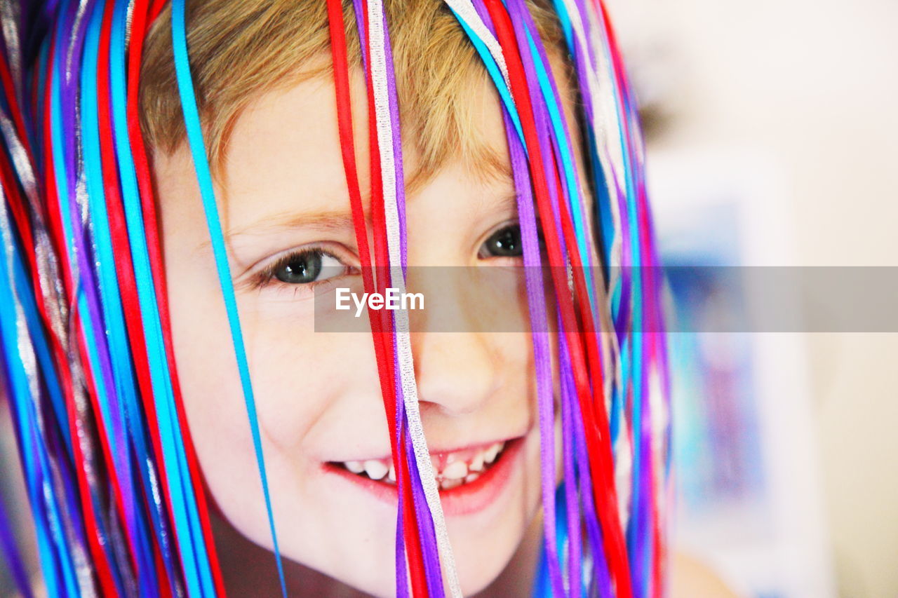 Portrait of smiling boy with ribbons on head