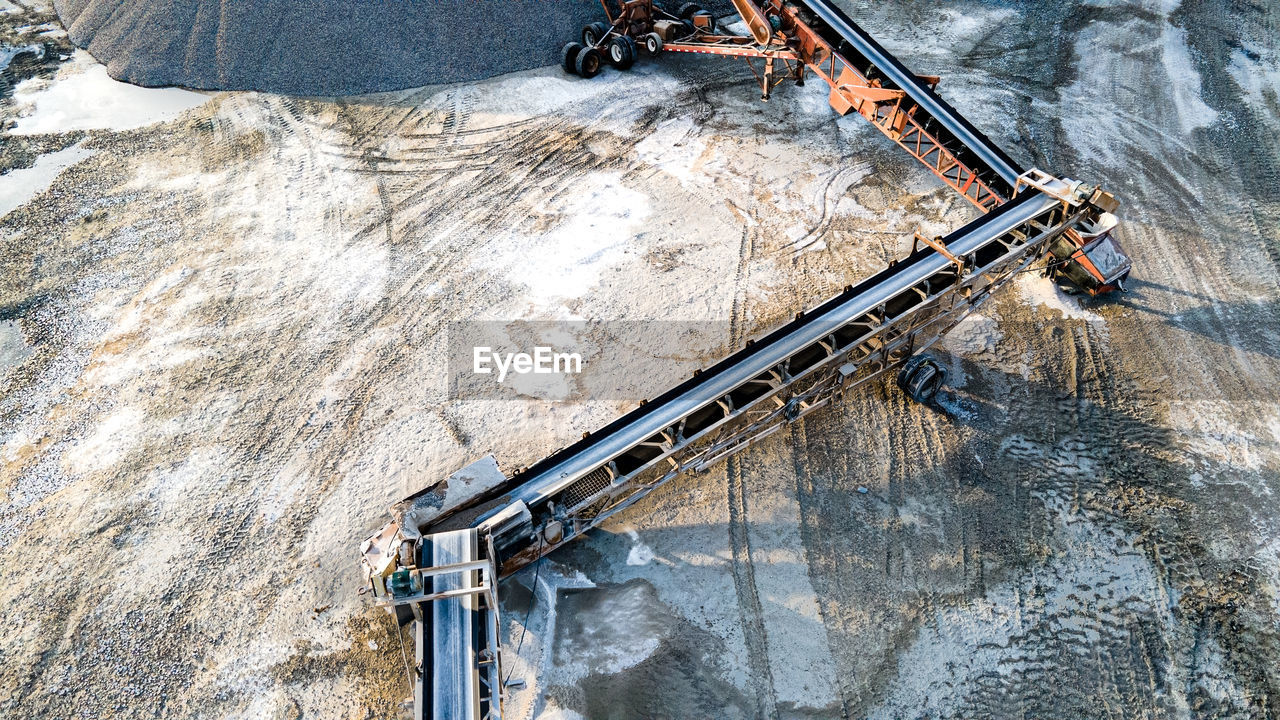 Open pit rock quarry with stone traveling on conveyors to massive gravel piles