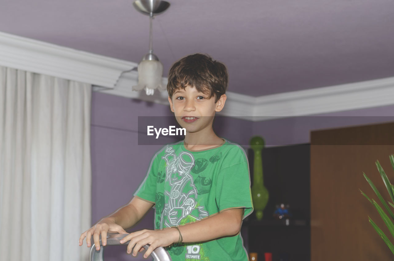 Portrait of young man standing at home