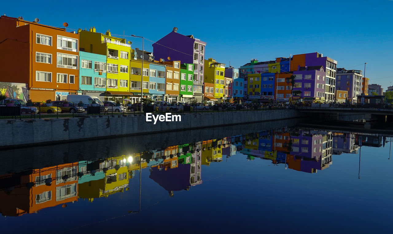 architecture, water, reflection, building exterior, built structure, cityscape, city, building, sky, nature, evening, blue, dusk, illuminated, residential district, skyline, waterfront, travel destinations, night, urban area, house, clear sky, waterway, no people, travel, city life, business finance and industry, outdoors, multi colored, landmark, transportation, tourism, business, industry, river, town, landscape, metropolis, metropolitan area, twilight
