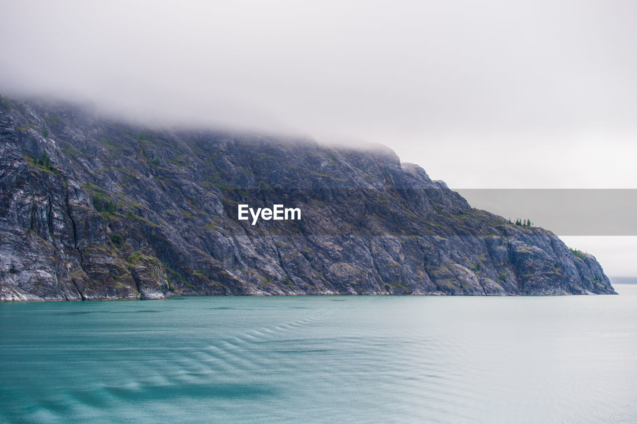 Scenic view of sea and mountains against sky