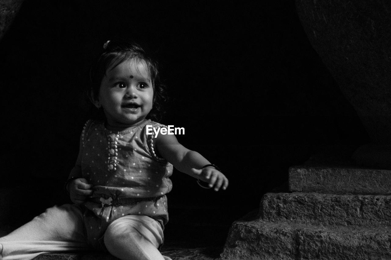 PORTRAIT OF CUTE BABY GIRL SITTING ON COUCH