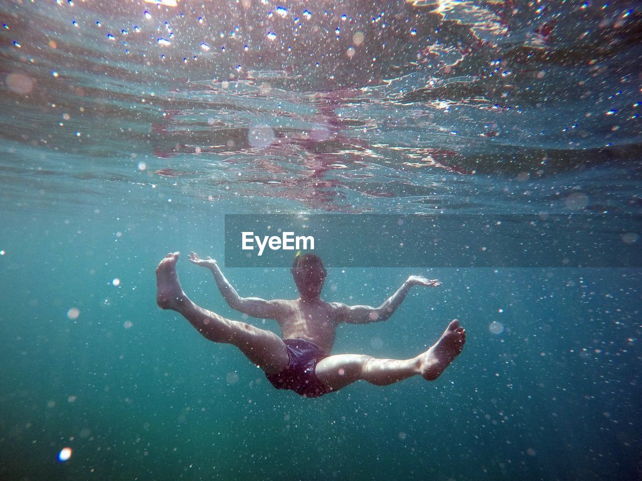 Full length of shirtless man swimming in sea