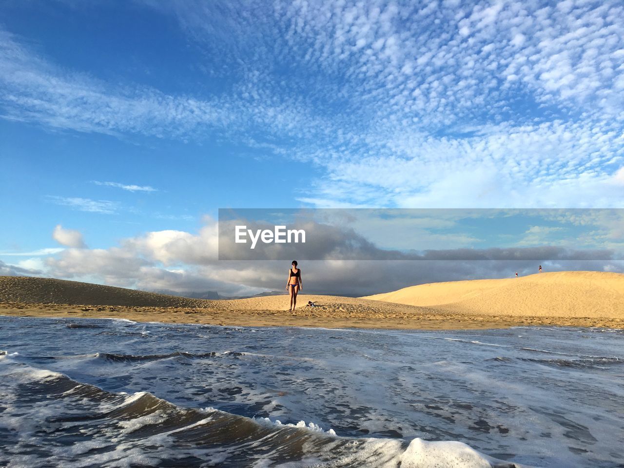 Scenic view of beautiful woman standing on beach