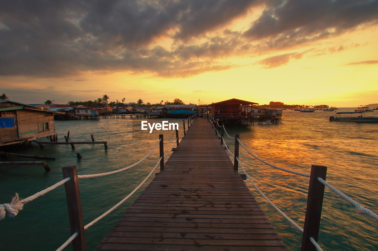 PIER OVER SEA AGAINST SKY AT SUNSET