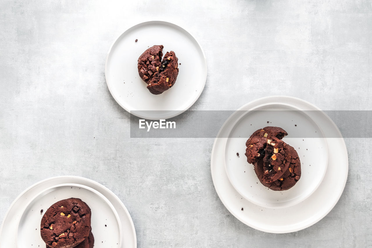 High angle view of chocolate cookies on white plates on table