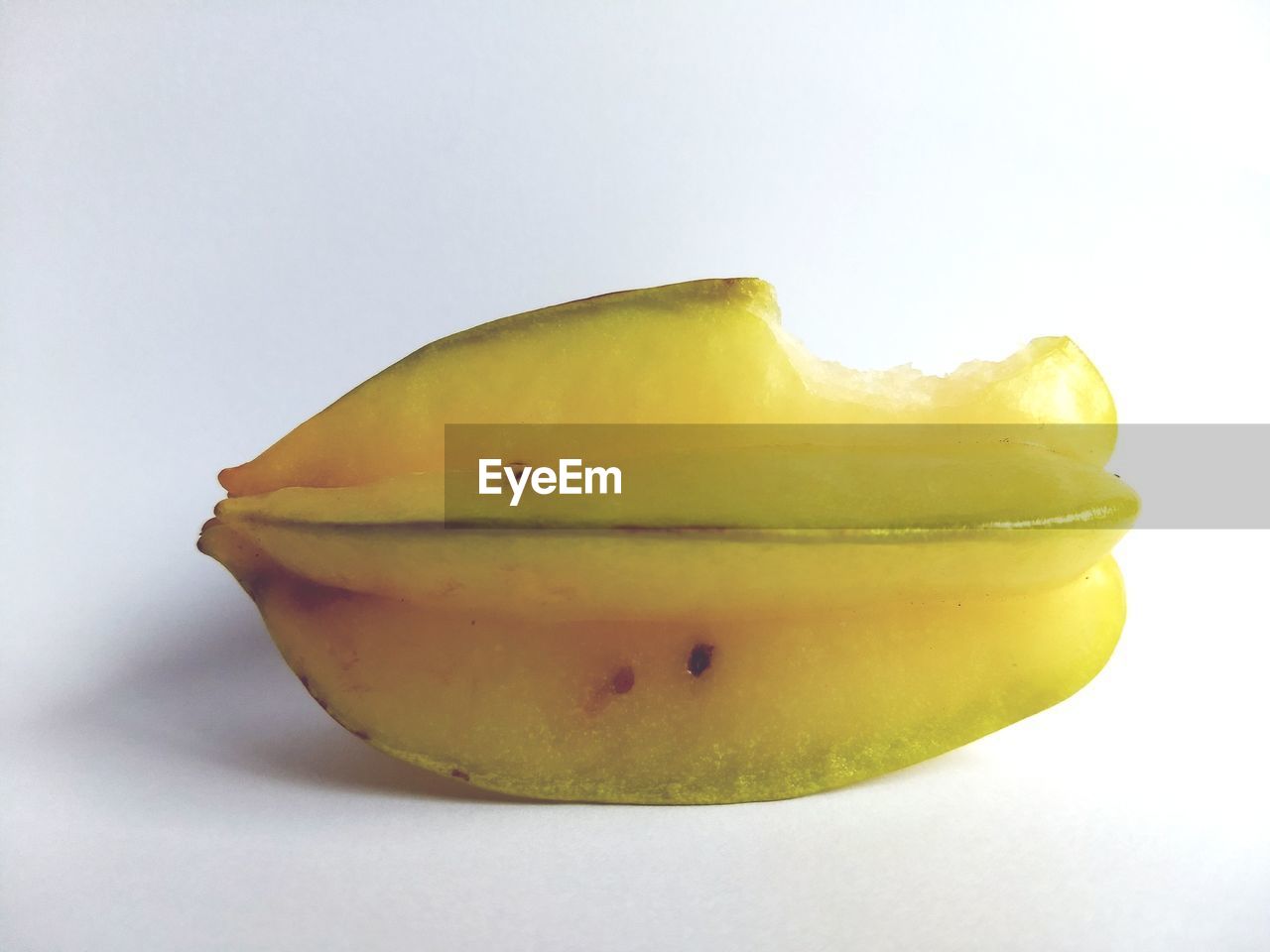 CLOSE-UP OF YELLOW FRUIT AGAINST WHITE BACKGROUND