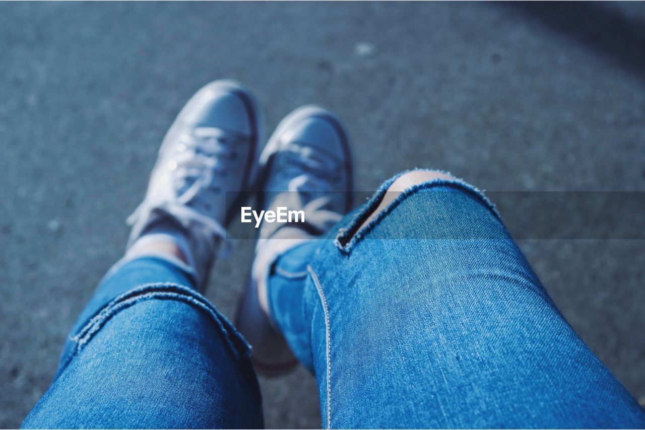 Low section of woman wearing torn jeans