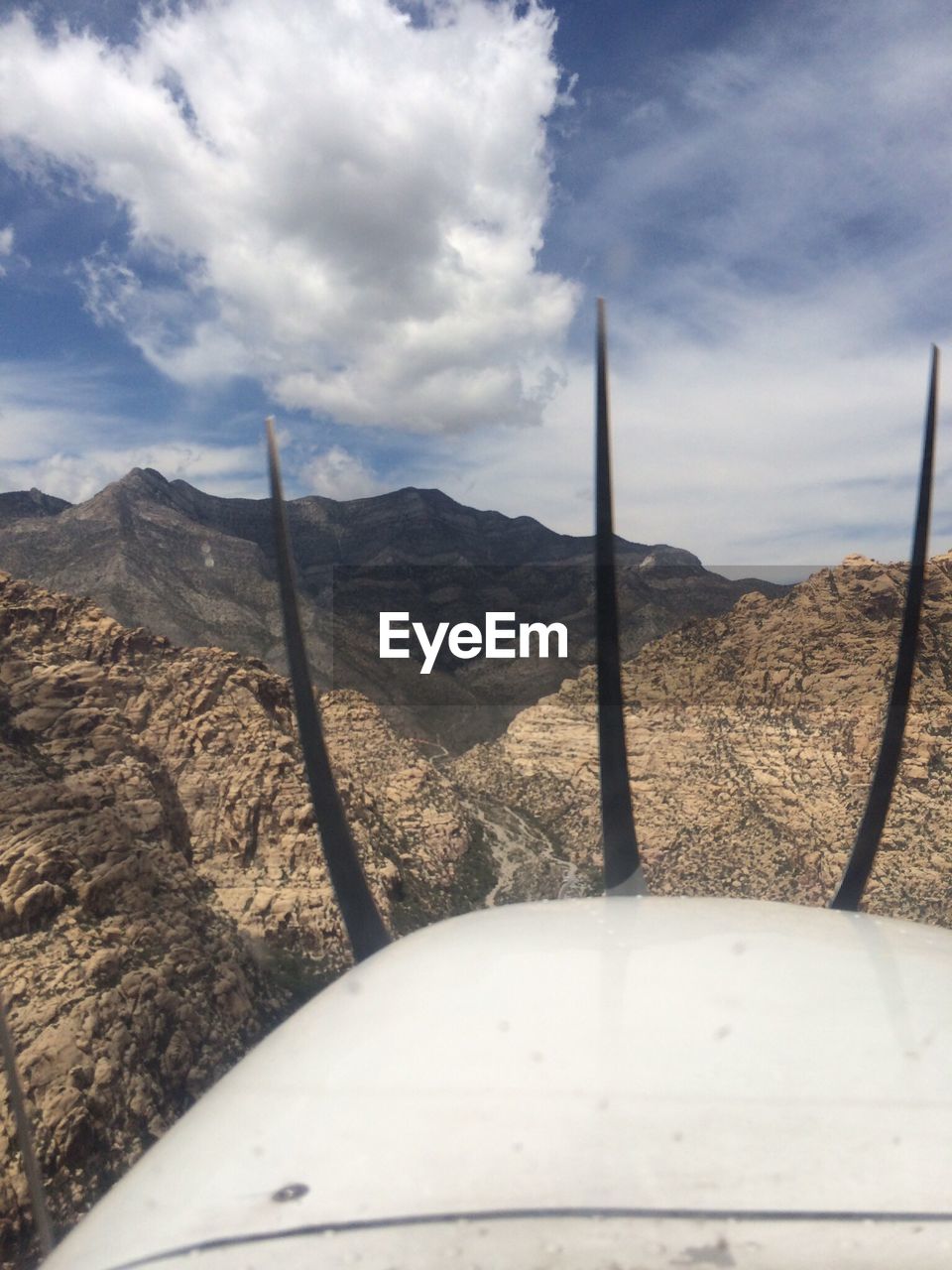 View of mountain range from air plane window with cloud sky in background