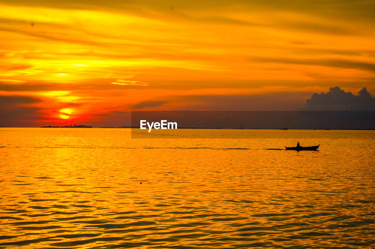 SILHOUETTE BOAT IN SEA AGAINST SKY DURING SUNSET