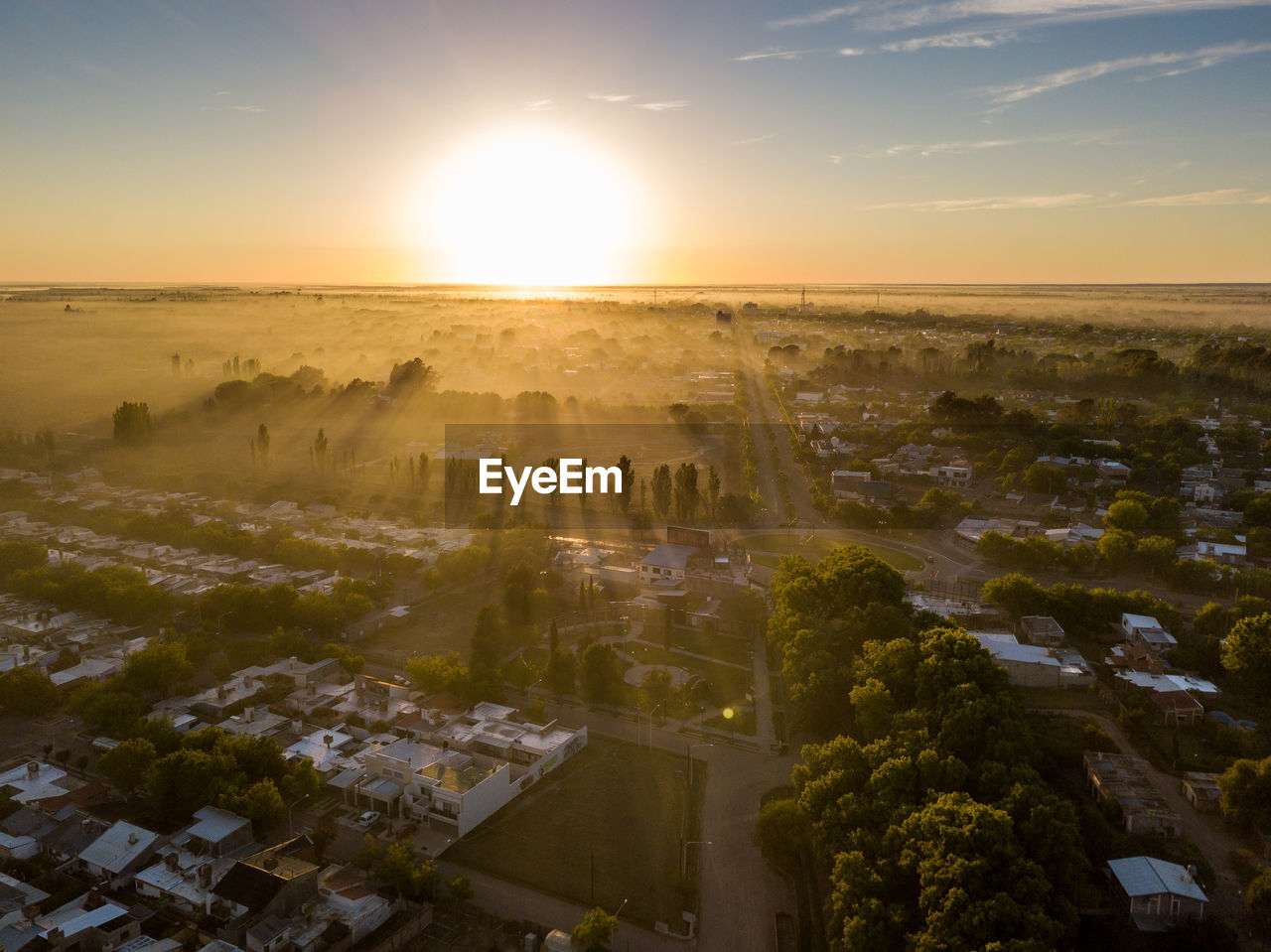 Aerial view of cityscape against sky during sunset