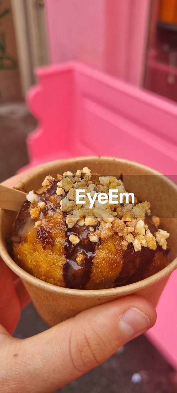 CLOSE-UP OF HAND HOLDING ICE CREAM IN PLATE