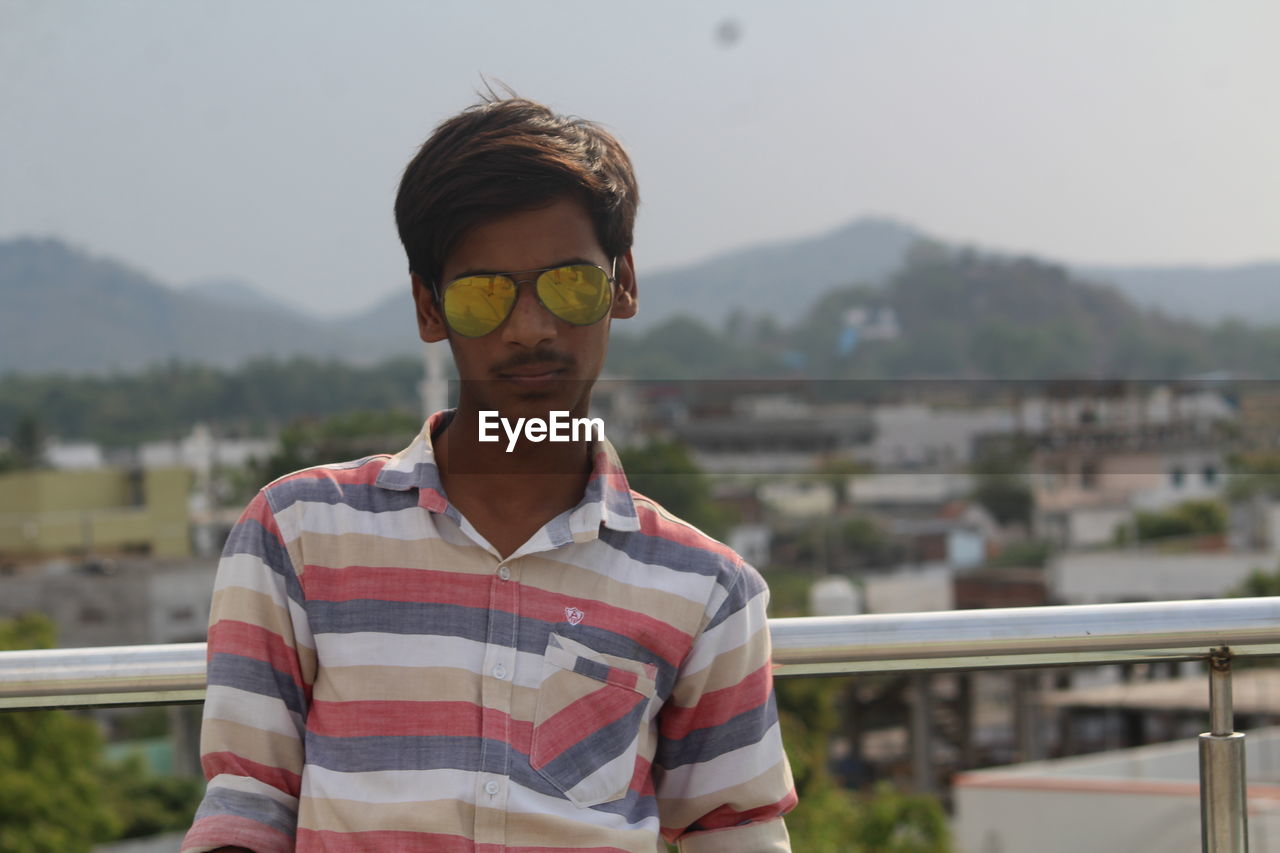 Man standing on building terrace against sky