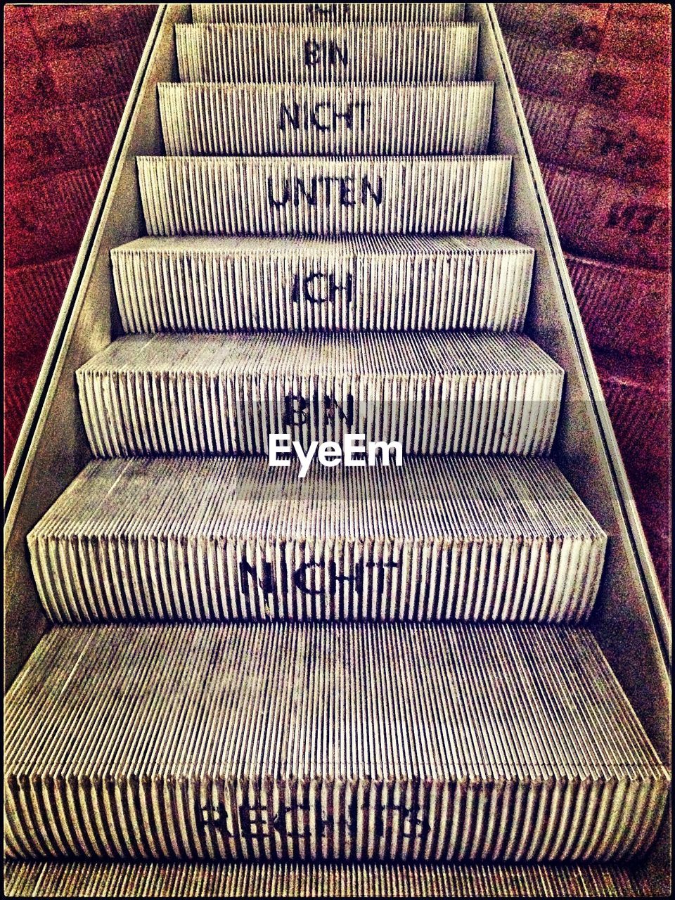 German text on steps of escalator