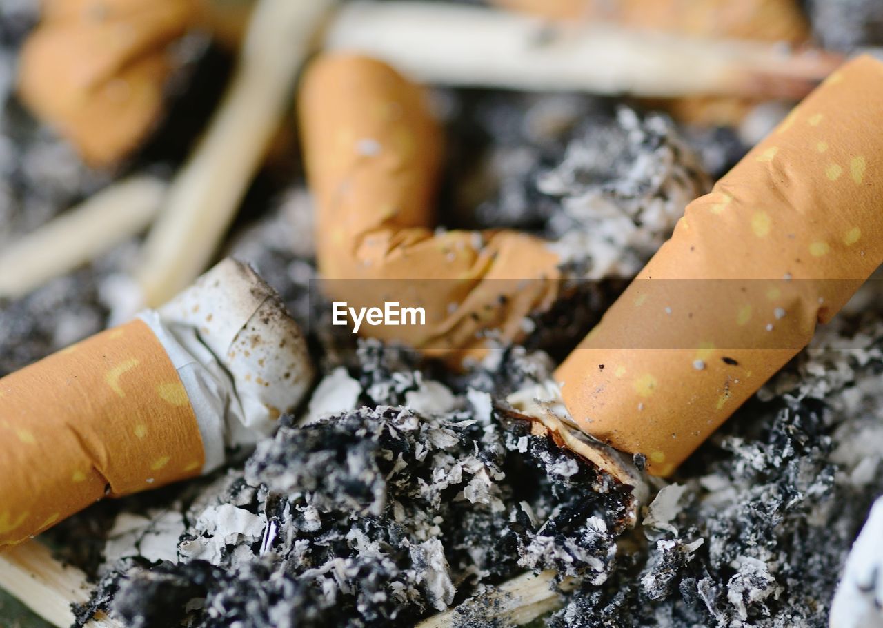 High angle view of cigarette butts and ash in tray