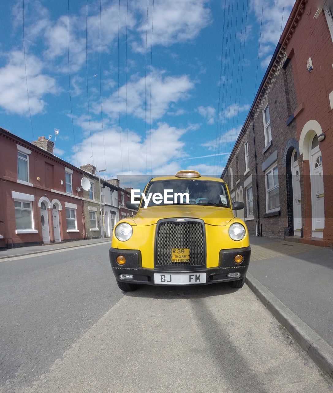 VEHICLES ON ROAD AGAINST BLUE SKY