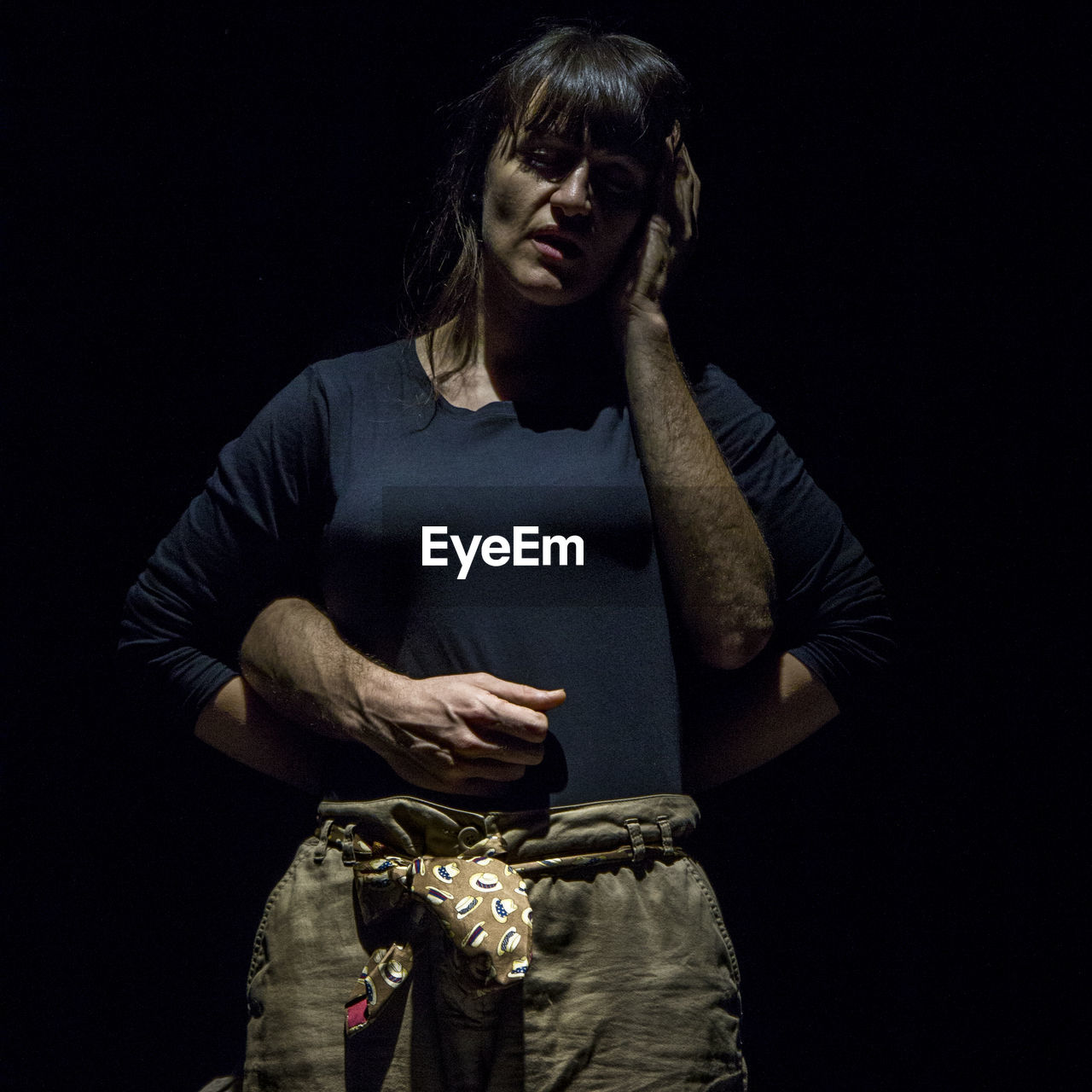 Cropped hands of man touching woman against black background