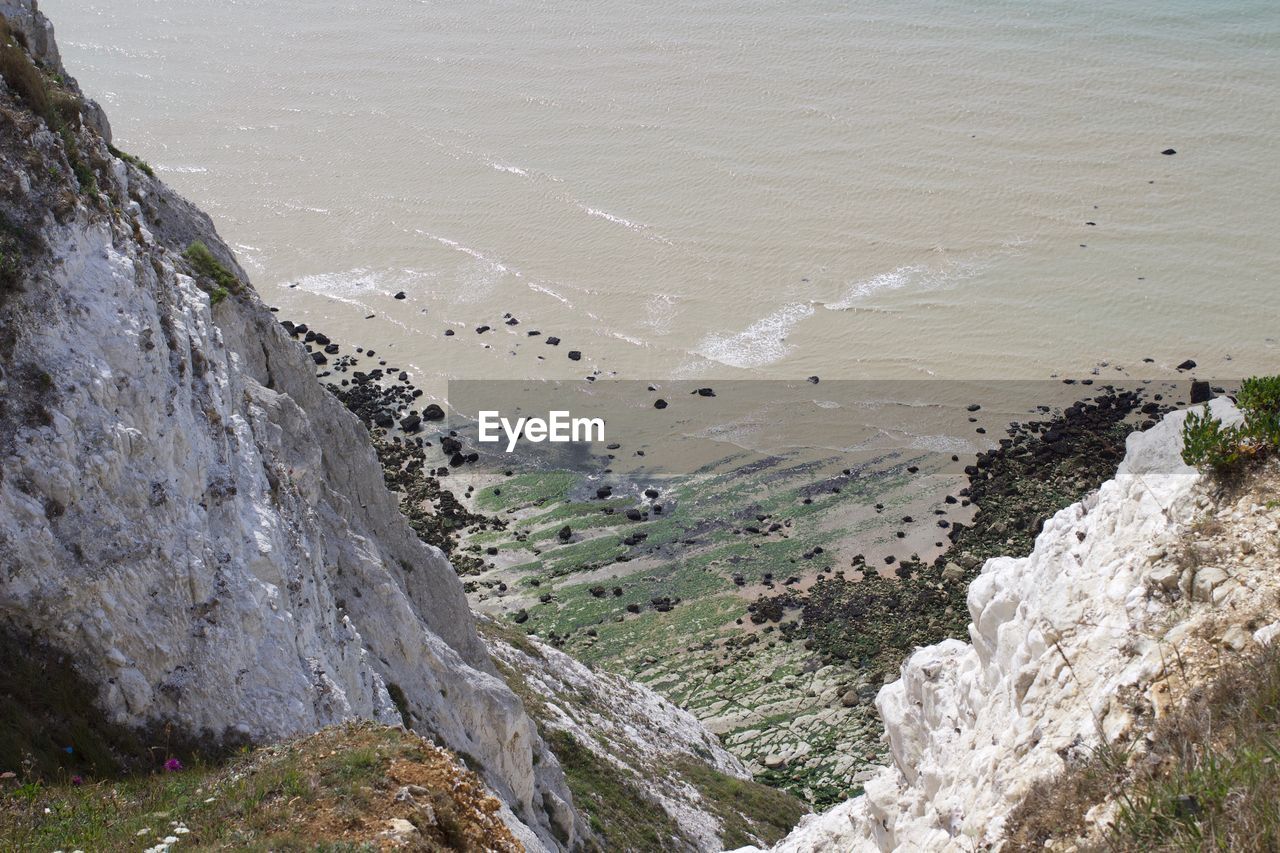 HIGH ANGLE VIEW OF ROCKS ON SHORE AT BEACH