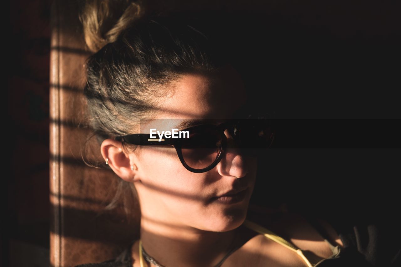 CLOSE-UP PORTRAIT OF YOUNG WOMAN WITH EYEGLASSES