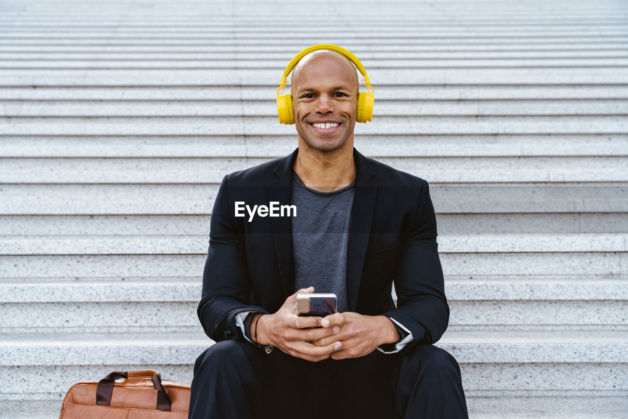 portrait of smiling young man using mobile phone