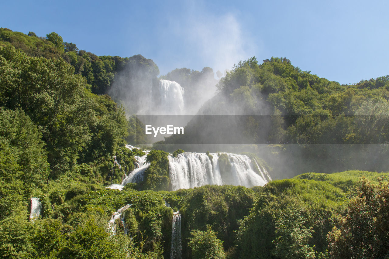 PANORAMIC VIEW OF WATERFALL IN FOREST AGAINST SKY