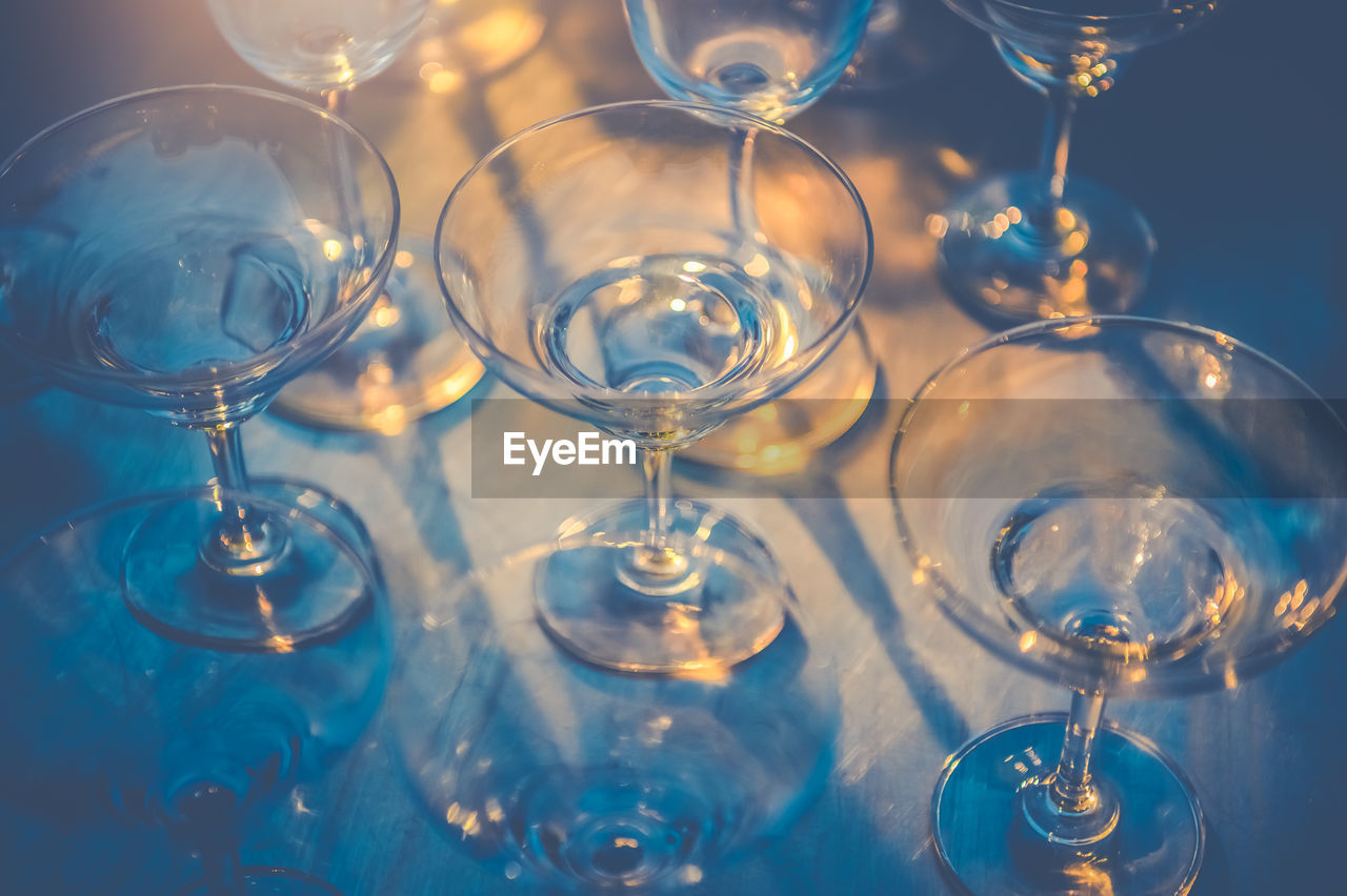 CLOSE-UP OF WINE GLASSES ON GLASS TABLE