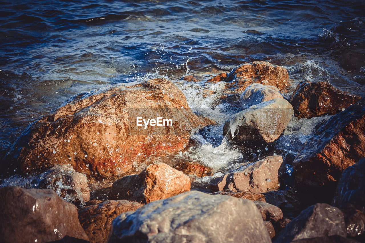 HIGH ANGLE VIEW OF ROCKS ON SHORE