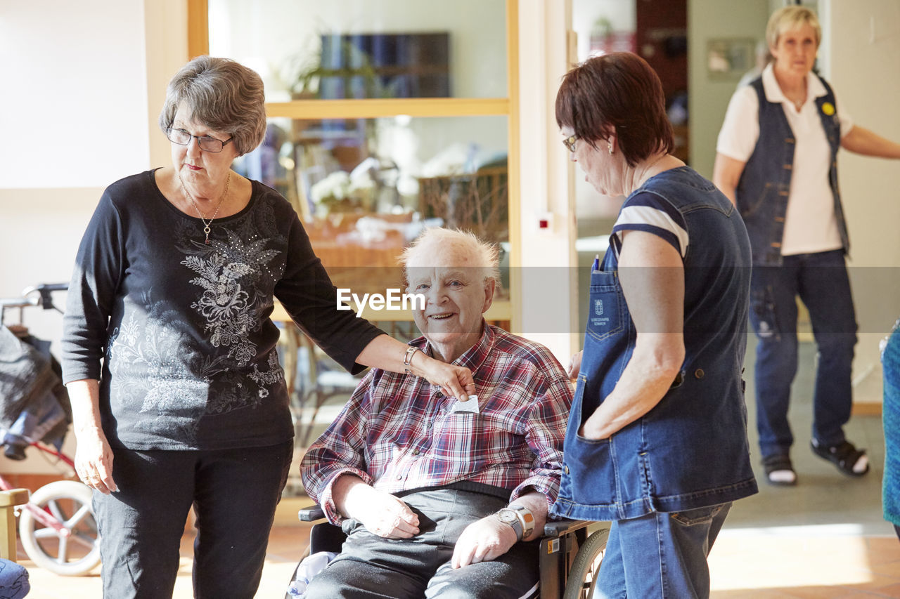 Nurses with smiling senior man in care home