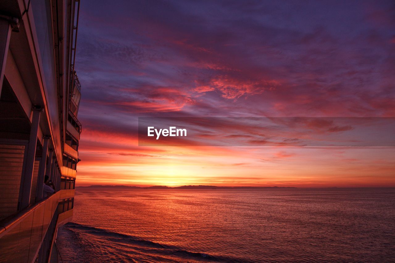 Boat over sea against sky during sunset