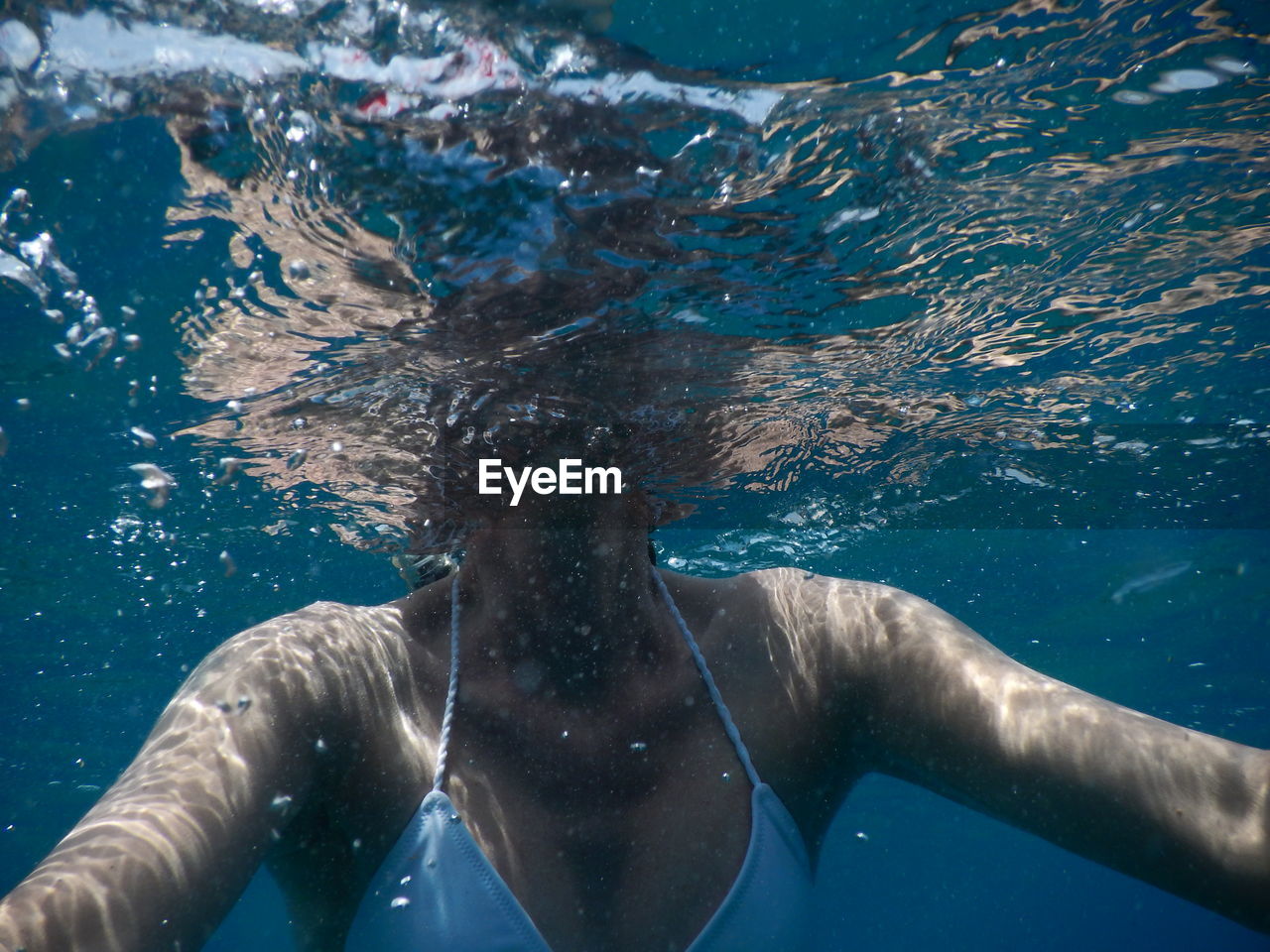 Midsection of woman swimming in sea