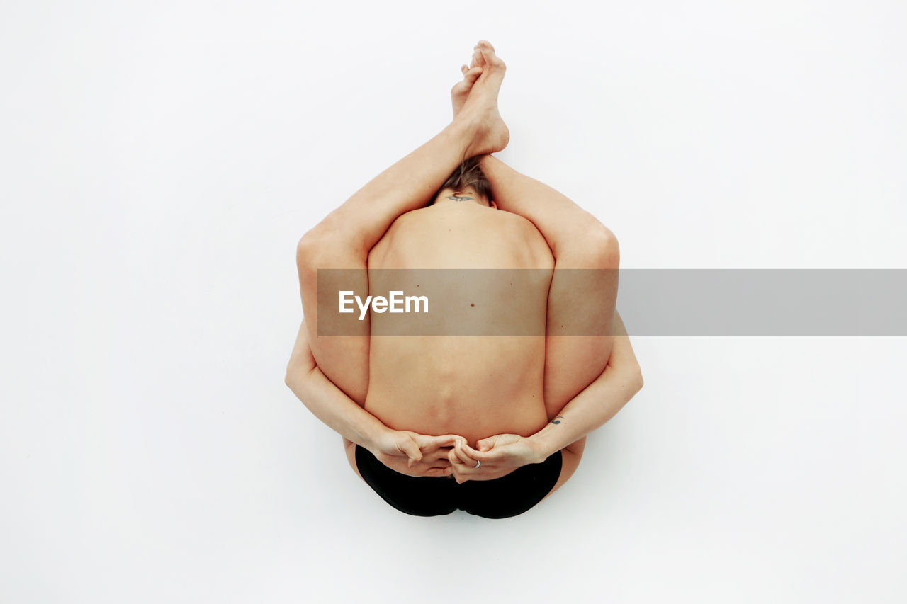 Young woman practicing yoga against white background