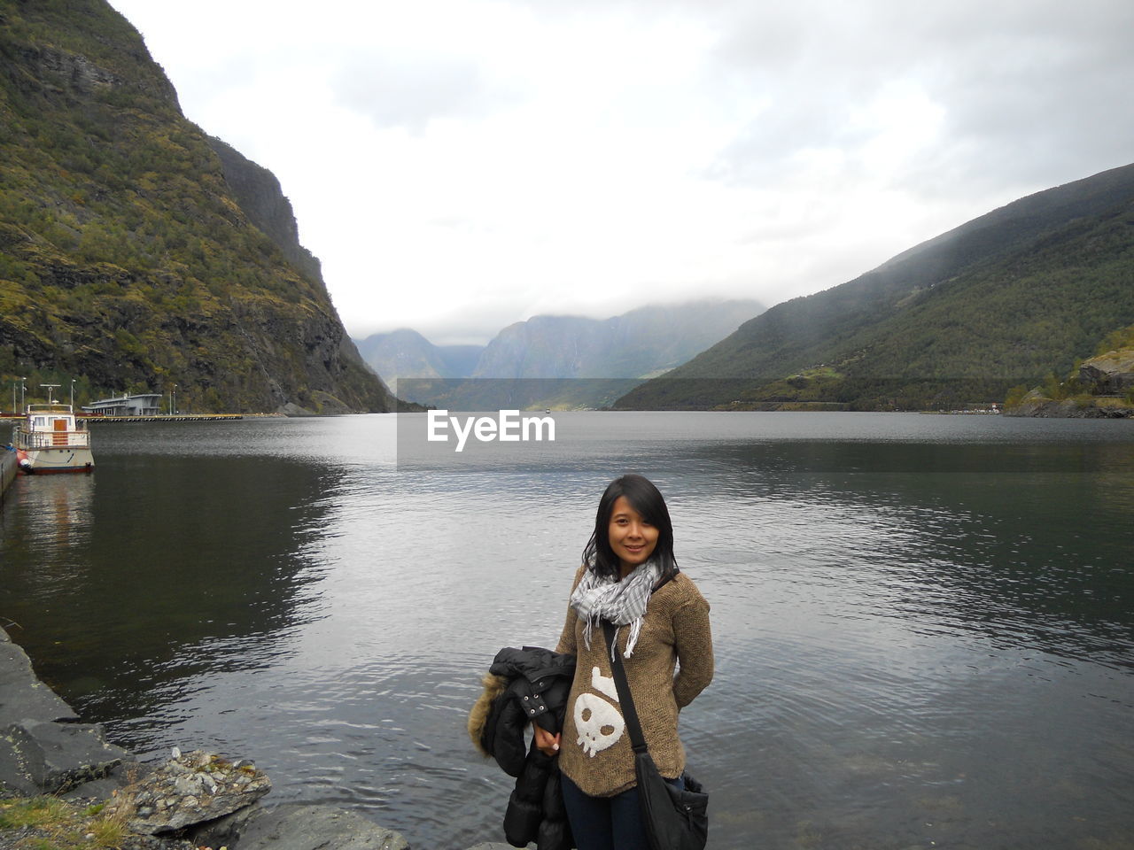 Portrait of woman standing against lake