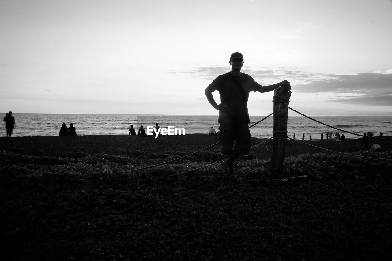 Silhouette people on beach against sky
