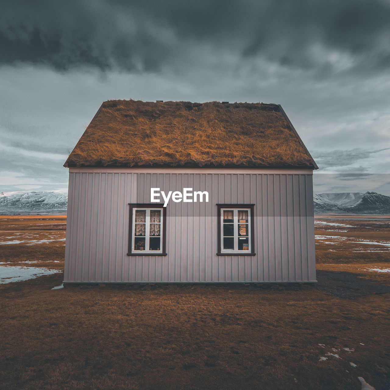 House on field against sky during winter