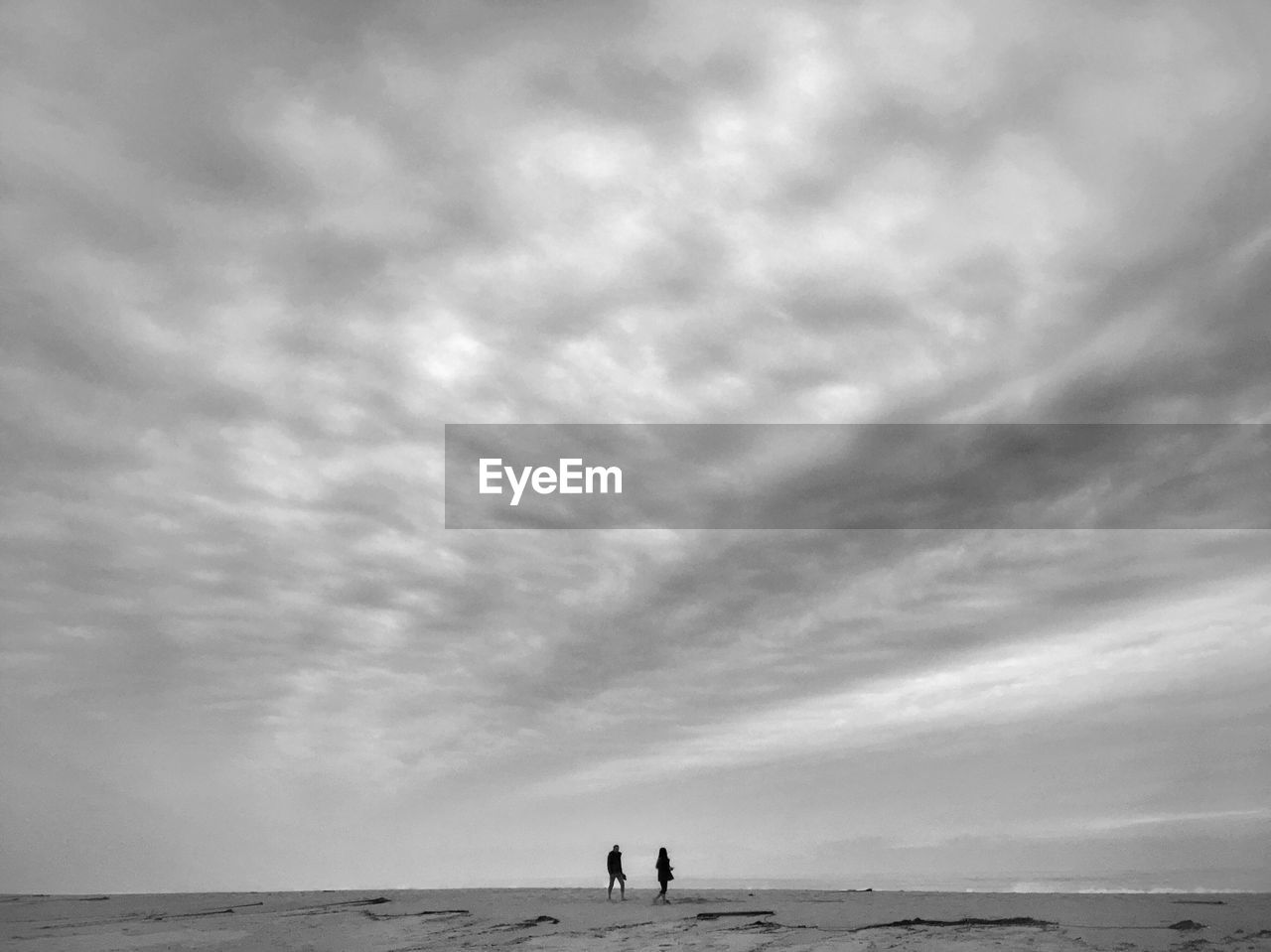 Men standing on beach against sky