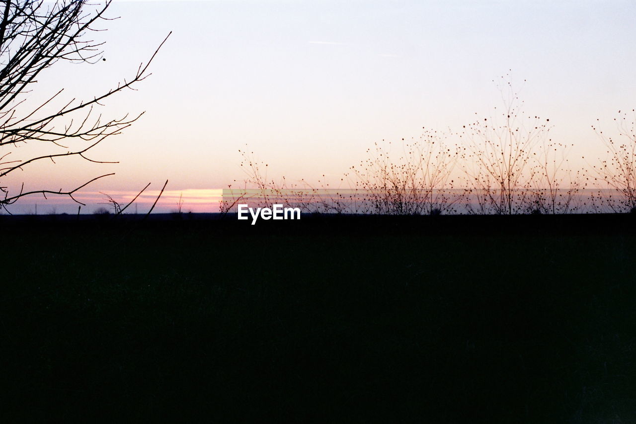 SILHOUETTE LANDSCAPE AGAINST CLEAR SKY DURING SUNSET