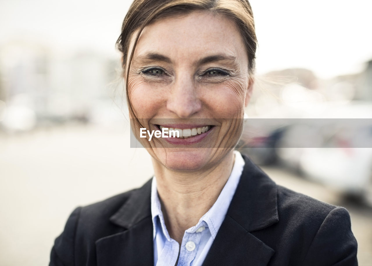 Portrait of happy mature businesswoman smiling outdoors