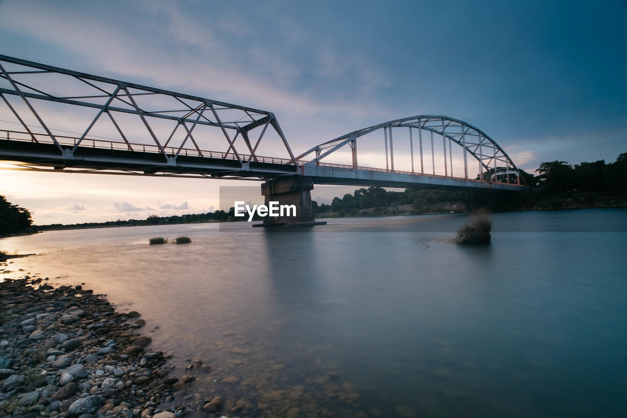 View of bridge over river against cloudy sky