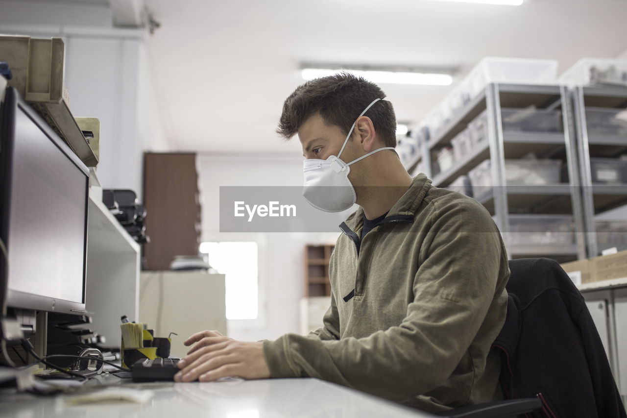 Man working on table with mask