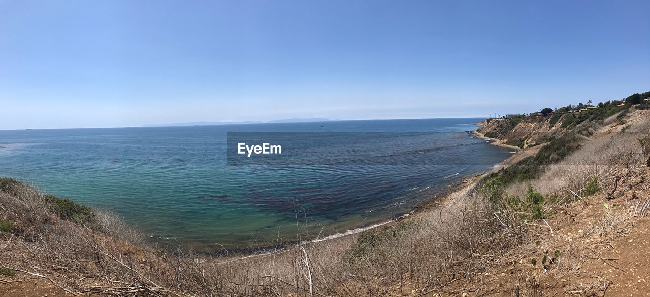 SCENIC VIEW OF BEACH AGAINST BLUE SKY