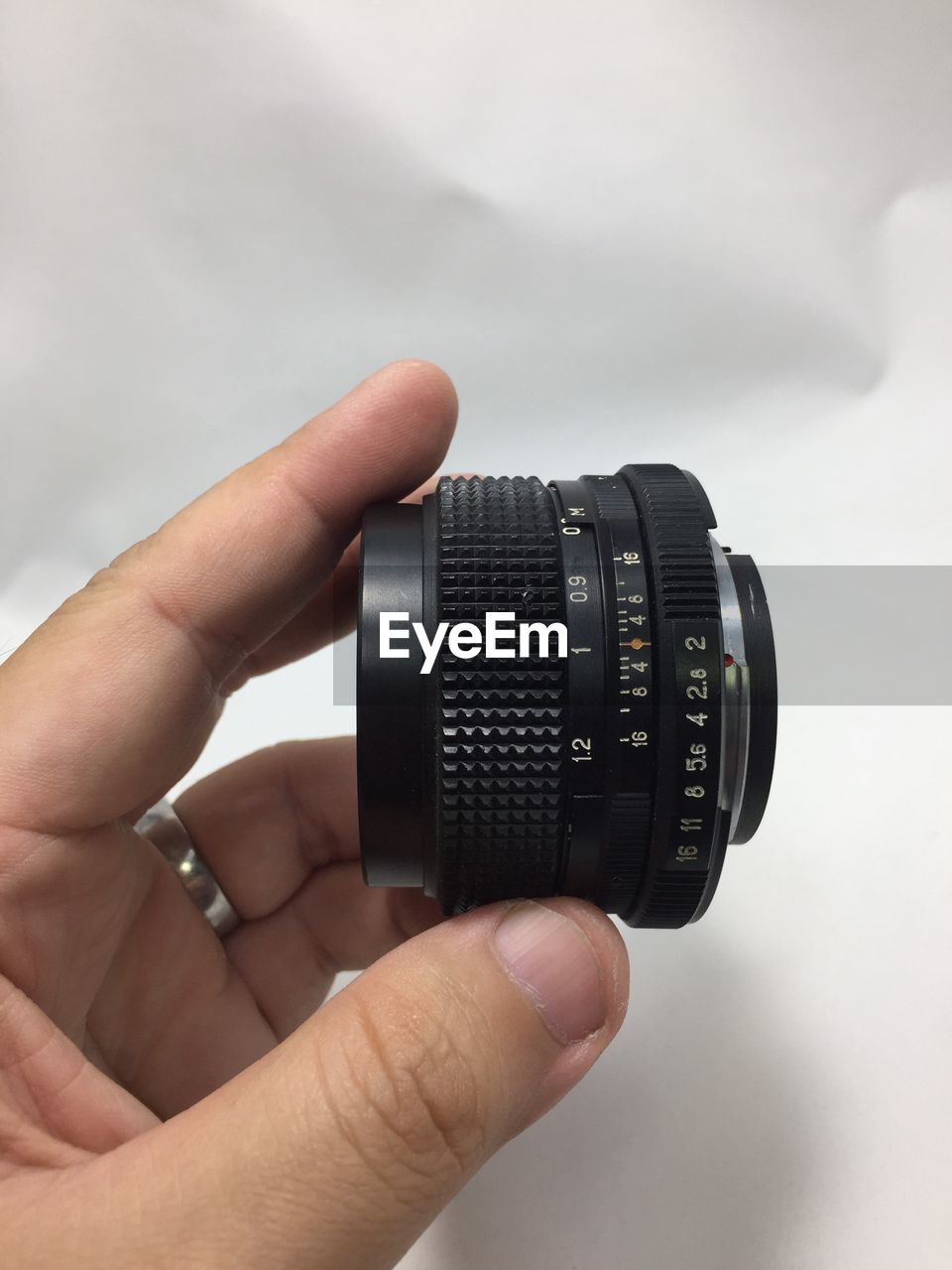 CLOSE-UP OF HAND HOLDING CAMERA AGAINST SKY